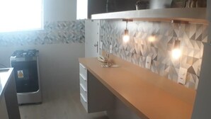 A kitchen with a modern design, featuring a wooden countertop and a geometric patterned backsplash. - Gohouse - Gomes 202 (Rio de Janeiro)