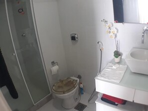 A small bathroom with a toilet, a sink, and a shower. - Gohouse - Pontoes 1202 (Rio de Janeiro)