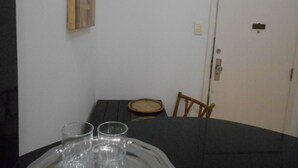 Una mesa de comedor con una bandeja que contiene tres vasos, un plato y una silla.