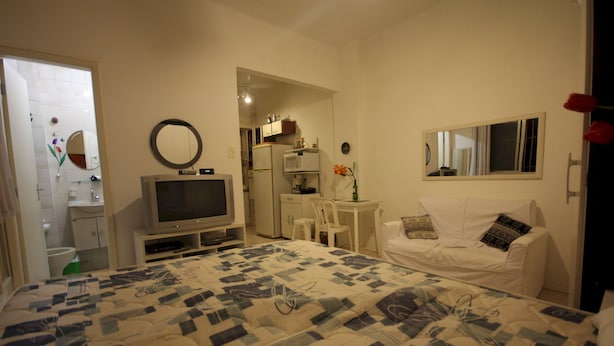 Una camera da letto con un letto, una televisione, una scrivania e una sedia.