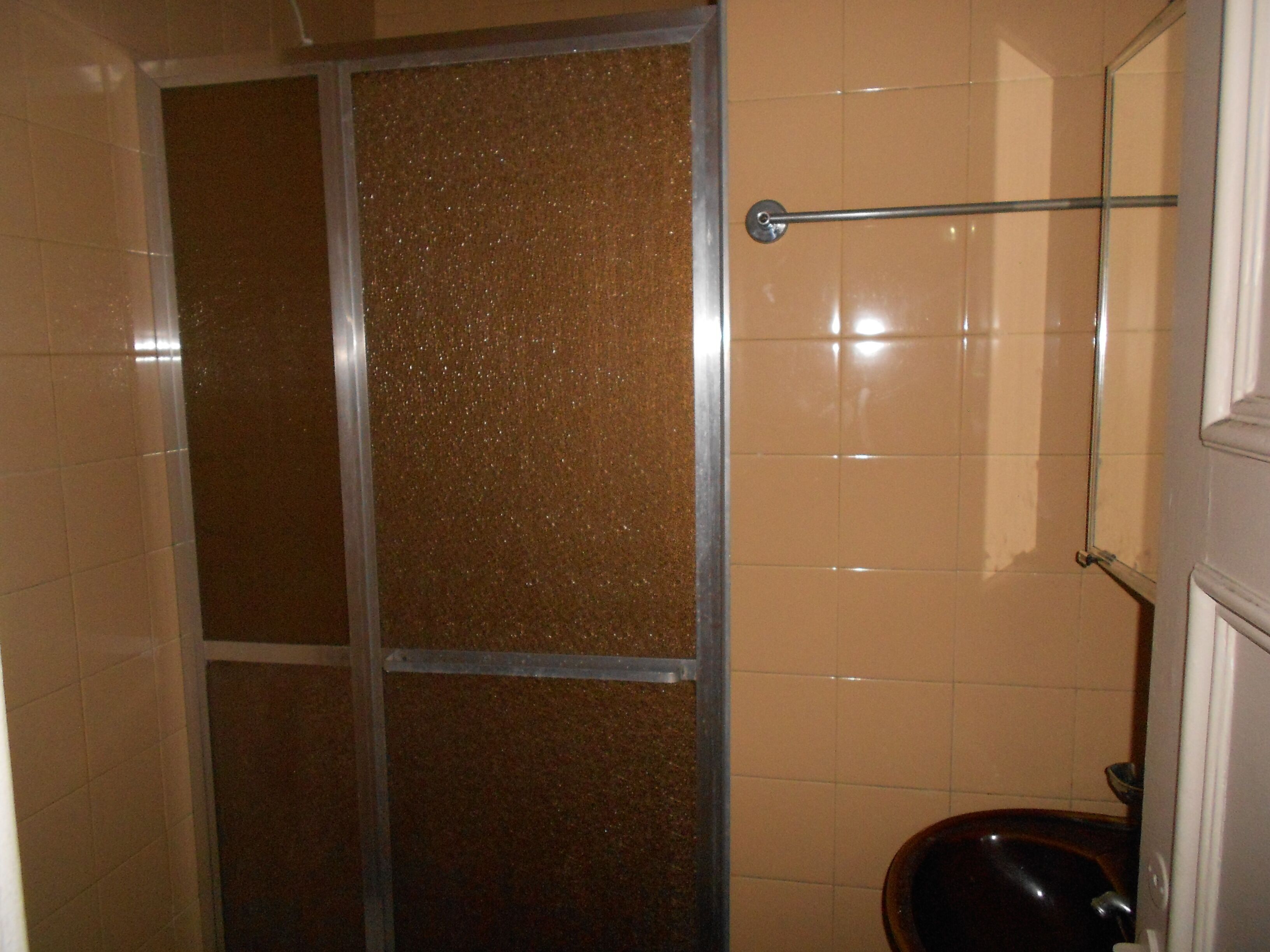 Une salle de bain équipée d’une douche, de toilettes et d’une barre d’appui.