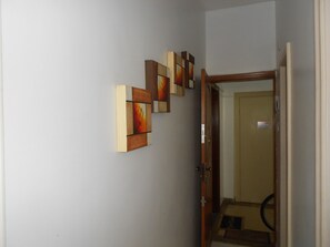Stunning hallway with abstract artworks and a door leading to a space.