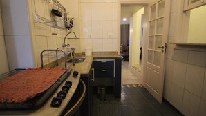 Una cocina compacta con estufa, fregadero y una pequeña encimera.