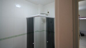 A bathroom with white tiled walls, a glass shower enclosure, and a towel rack on the wall. - Gohouse - Visconde 206 (Rio de Janeiro)