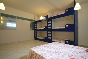 A bunk bed room with a floral bedspread and two pendant lights. - Gohouse - Visconde 206 (Rio de Janeiro)