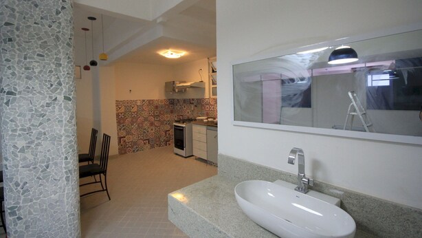 A modern bathroom with a large sink, a mirror, and a tiled backsplash. - Gohouse - Visconde 206 (Rio de Janeiro)