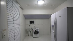 A laundry room with a washing machine, a sink, and a refrigerator. - Gohouse - Visconde 206 (Rio de Janeiro)
