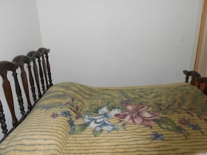 A bed with a floral bedspread and a wooden headboard. - Gohouse - Siqueira 1003 (Rio de Janeiro)