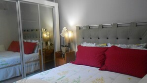 A bedroom with a bed, a wardrobe, and a nightstand with a lamp. - Gohouse - Gustavo 404 (Rio de Janeiro)