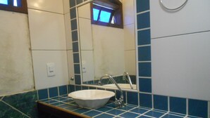 A bathroom with a white sink, blue-tiled walls, and a mirror. - Gohouse - Suite Tonelero 01 (Rio de Janeiro)