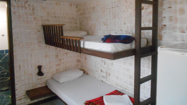 A bunk bed room with a wooden ladder, a white mattress, and a small table. - Gohouse - Suite Tonelero 01 (Rio de Janeiro)