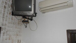 Une salle de bain équipée d’un téléviseur fixé au mur, d’un climatiseur et d’une baignoire.