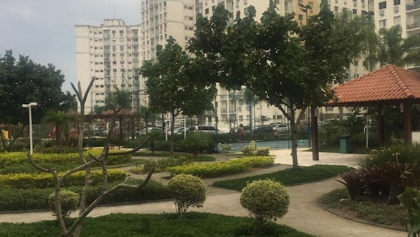 A landscaped garden with pathways, trees, and a gazebo.