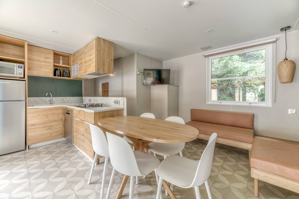 Een moderne keuken met houten kastjes, een eettafel en stoelen.