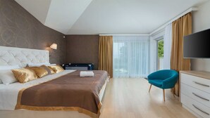 A modern hotel room with a large bed, a TV, a desk, and a chair. - Villa Almedina - perfect holiday destination with a pool, whirlpool and sauna by MyWaycation (Ljutici)