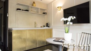 A modern kitchen with a built-in island, a flat-screen TV, and a potted orchid on the island. - House of Amstel (Amsterdam)