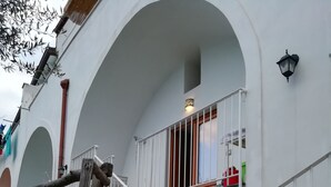 Ein weißes Gebäude mit einer Treppe, die zu einem Balkon führt.