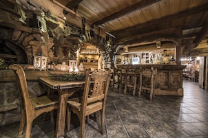 Un interior rústico con paredes de piedra, muebles de madera y una zona de bar.