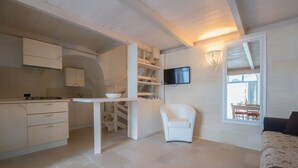 A compact living space with a kitchen, dining area, and seating area. - Casa Daniele (Ostuni)
