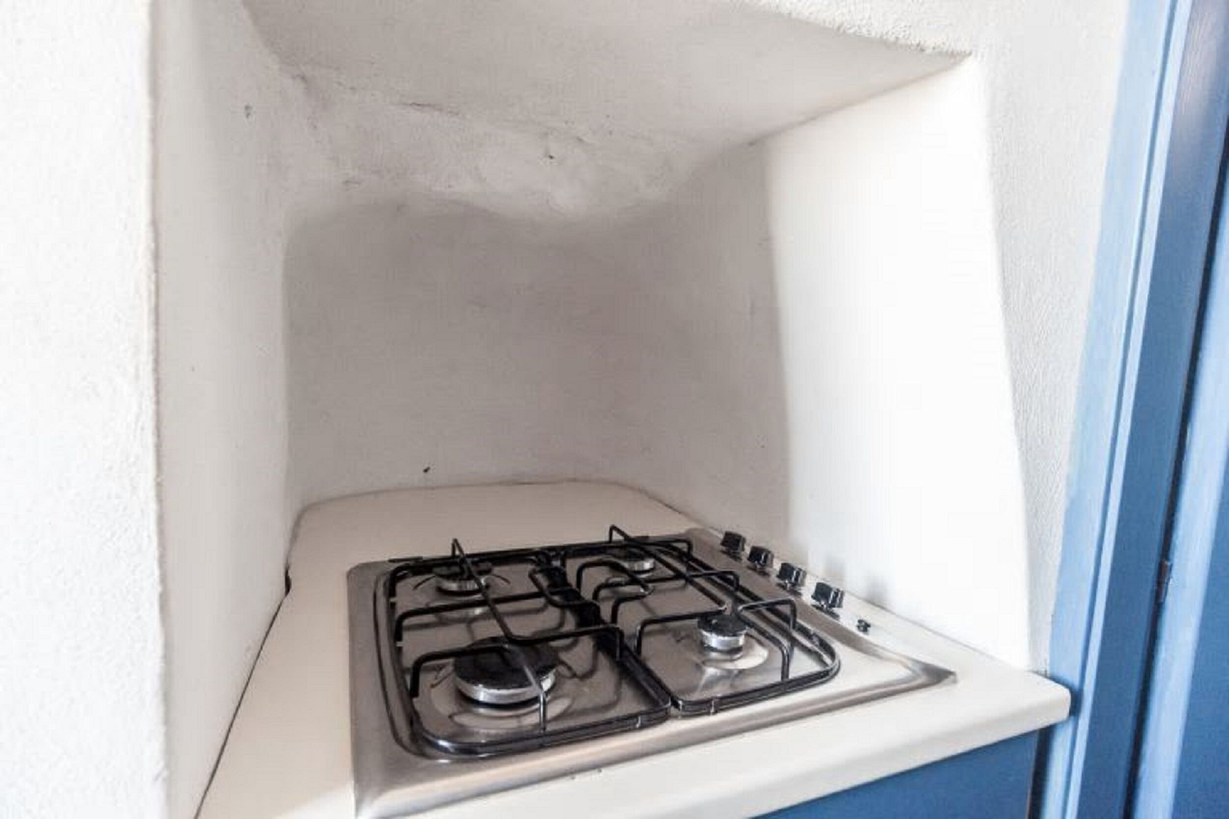 Una cocina pequeña con una estufa blanca y armarios azules.