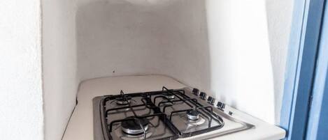Una cocina pequeña con una estufa blanca y armarios azules.