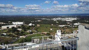 A high vantage point overlooking a cityscape with buildings, roads, and greenery. - Casina Nina (Ostuni)