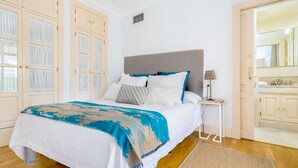 A neatly arranged bedroom with a large bed, a bedside table, and a wardrobe. - Genteel Home Vinuesa Terrace (Seville)
