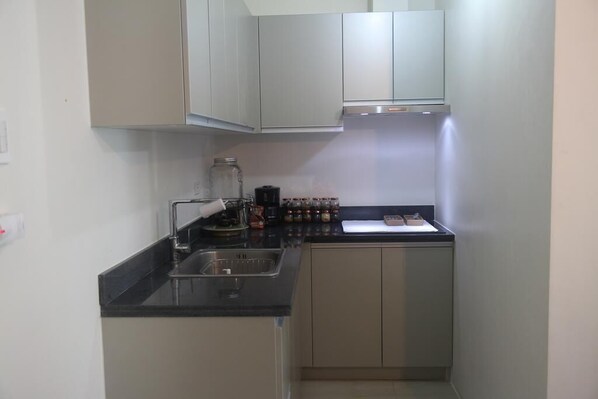 Een koelkast met diepvriezer, een microgolfoven, een kookplaat