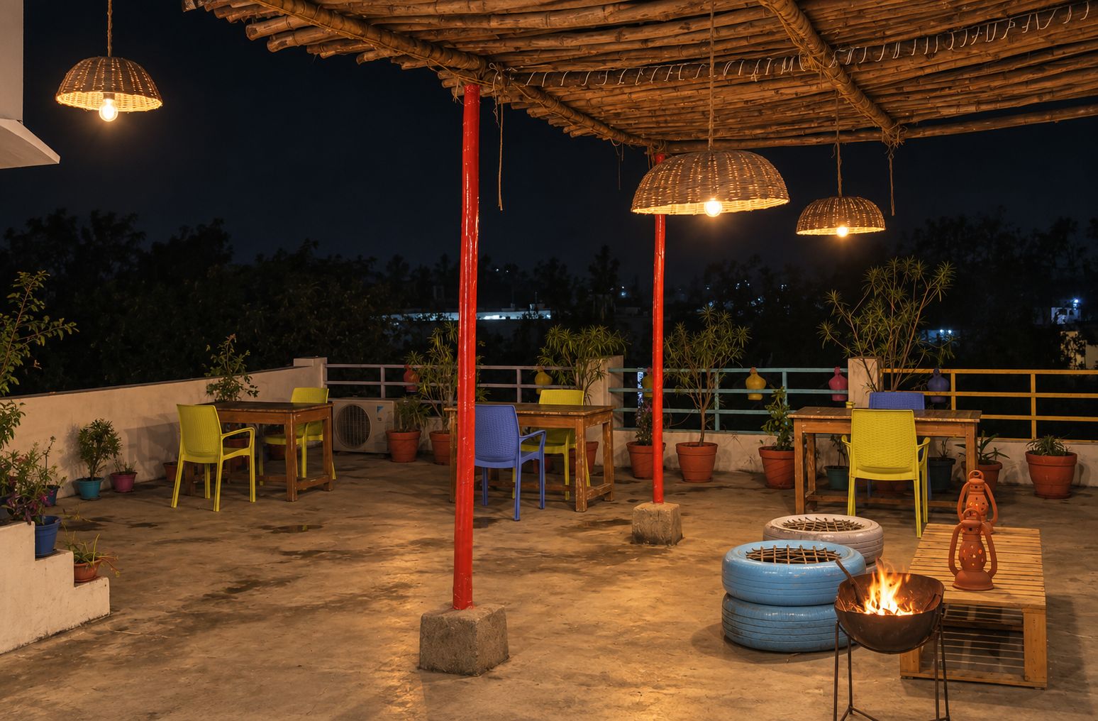 An outdoor patio area with tables and chairs, potted plants, and a fire pit.