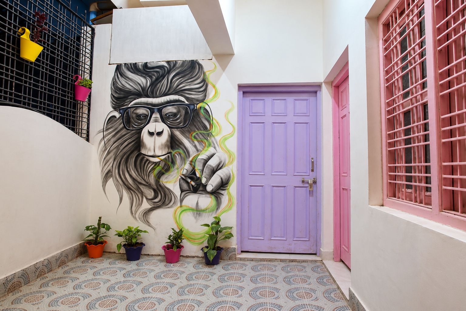 A hallway with a purple door, a mural of a gorilla, and potted plants.