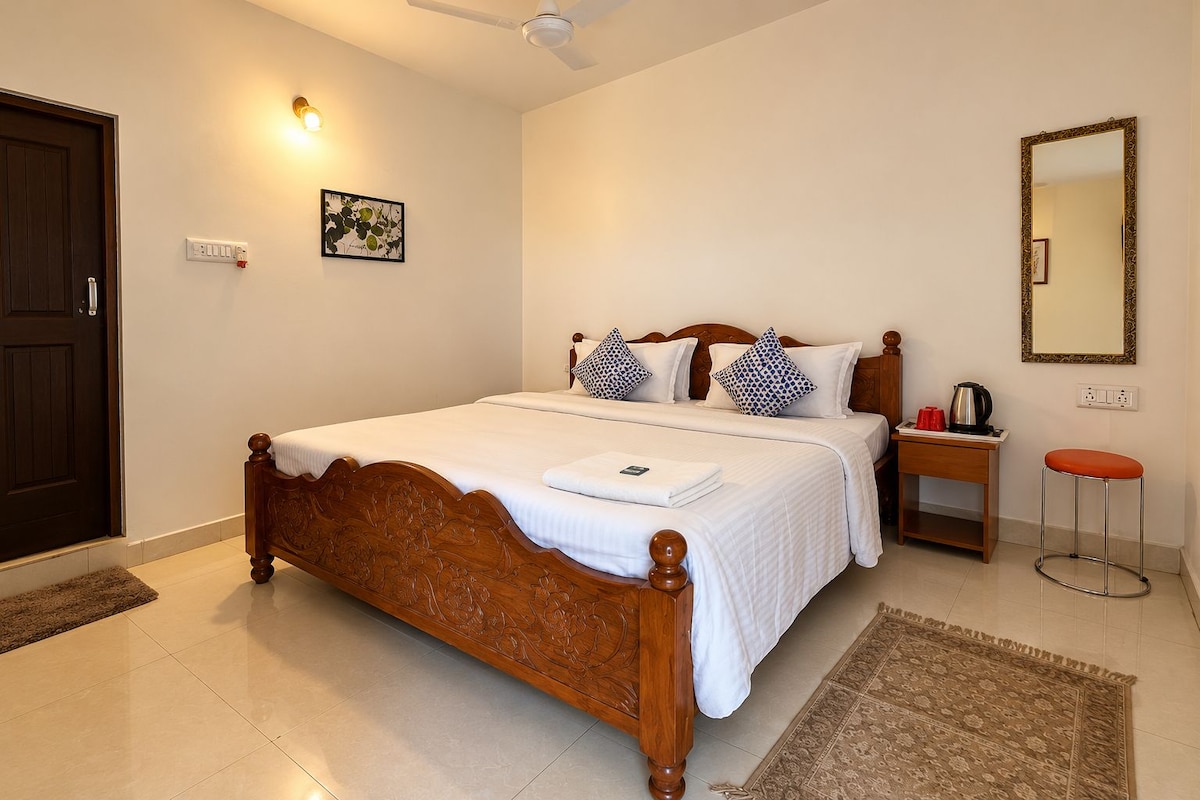 A bedroom with a wooden bed, a nightstand, a mirror, and a red stool.