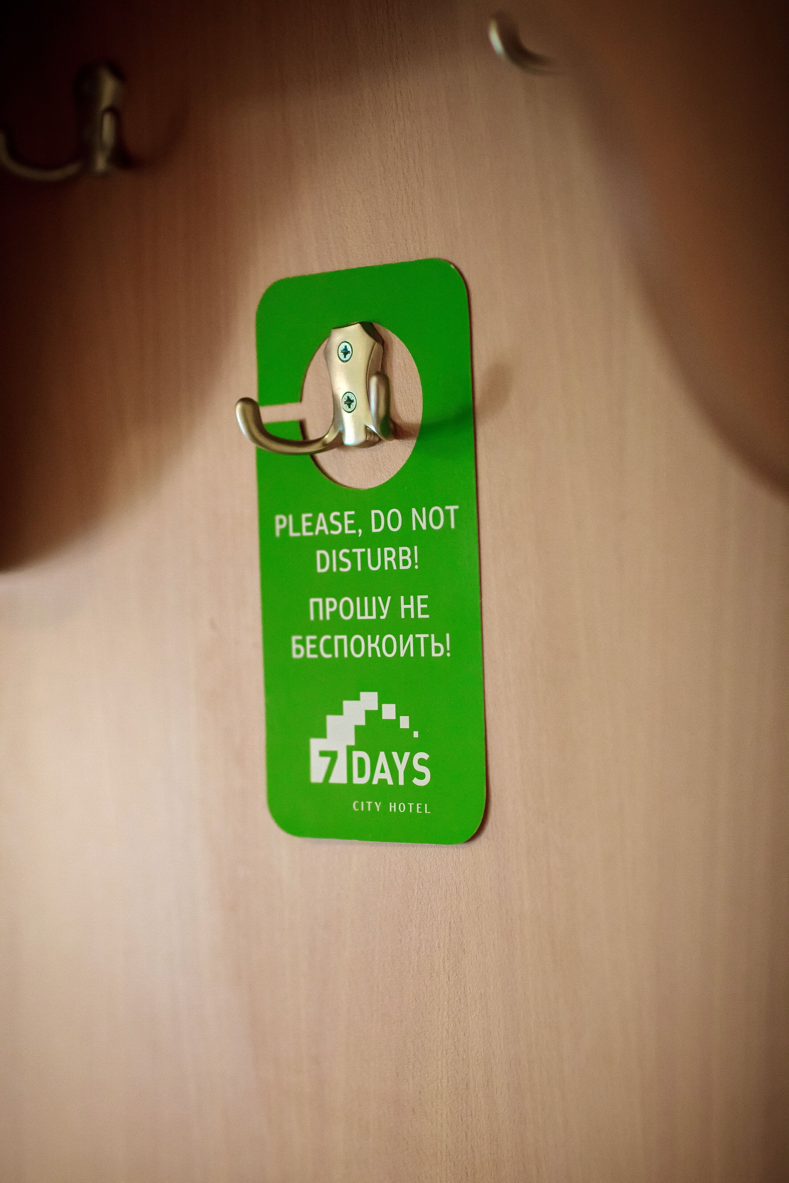 A green hotel key card with a lock and a message in English and Russian.