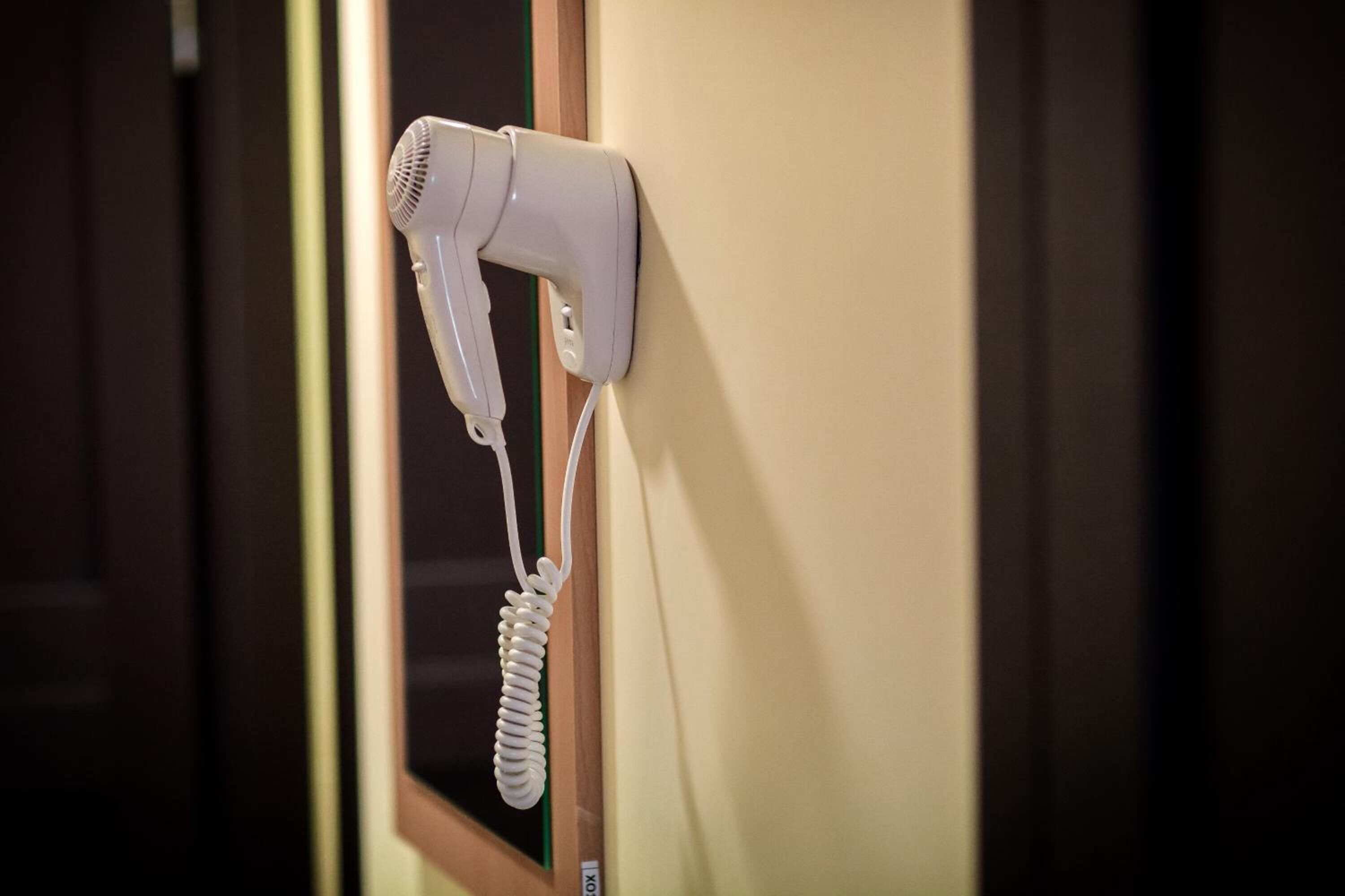 A hair dryer mounted on a wall near a door.