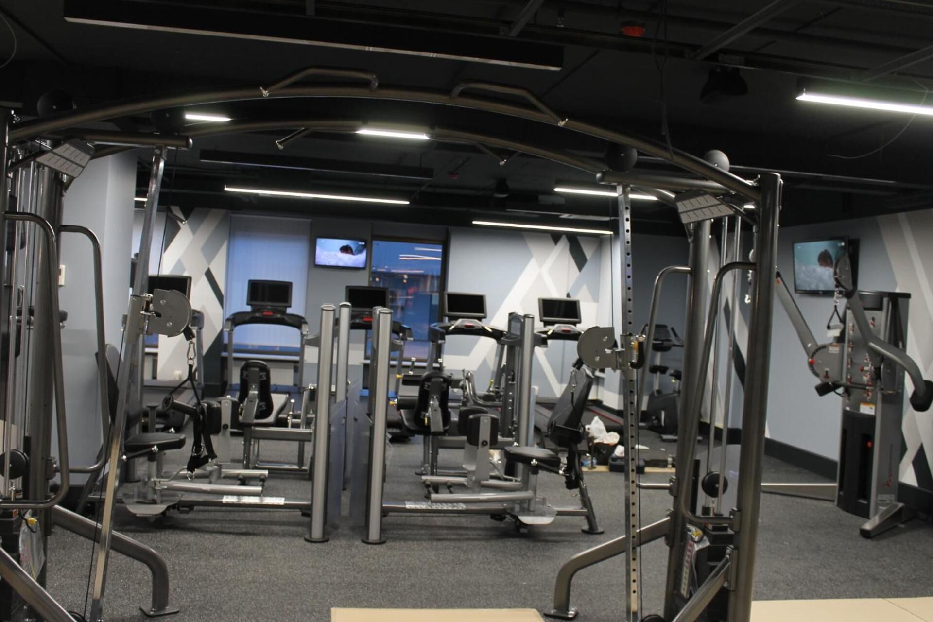 A gym with various exercise machines, including weight machines and cardio equipment.