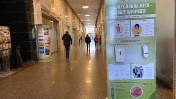 Un pasillo con carteles informativos, un directorio y una zona de recepción.