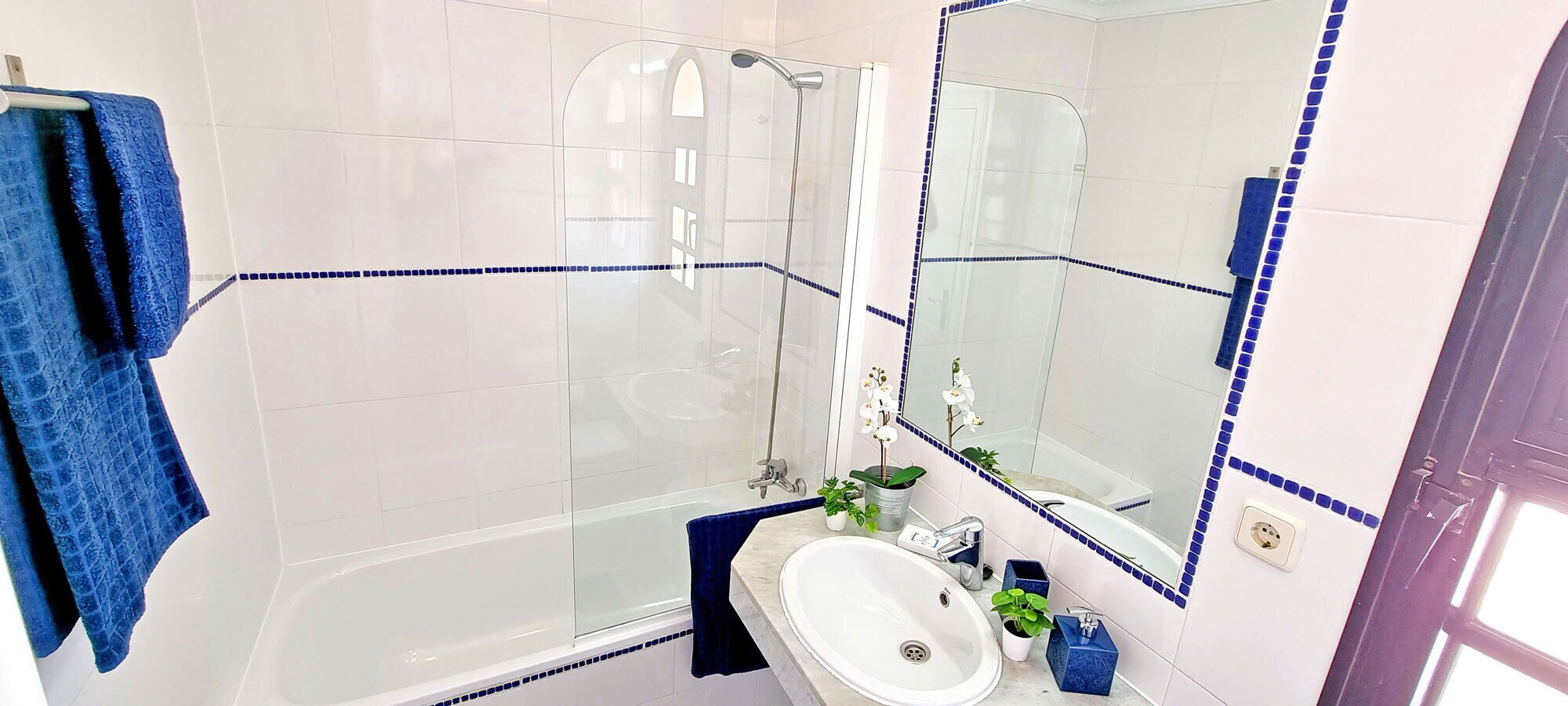 A bathroom with a bathtub, a shower, a sink, and a mirror.
