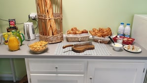 A breakfast buffet with bread, pastries, and beverages on a counter. - Camping Moulin du Roy (Revel)