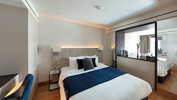 Ein modernes Hotelzimmer mit einem großen Bett, einem Schreibtisch und einem Spiegel.