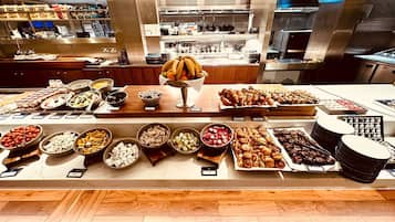 A buffet with various food items and a central fruit bowl.
