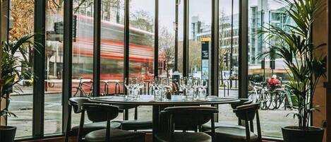 Ein Restaurant mit Blick auf eine belebte Straße und eine Straßenbahn.