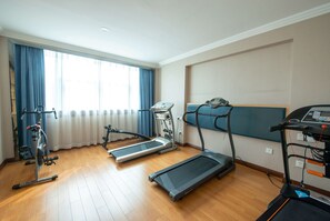 Ein Fitnessraum mit Laufbändern, einem Ergometer und einem Rudergerät.