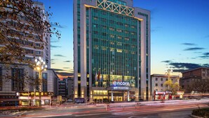 Un hotel moderno con un llamativo letrero 'encore', fachada de vidrio y diseño estructural en la parte superior.