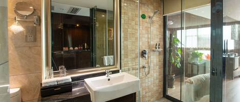 A modern bathroom with a large mirror, a sink, and a shower area.