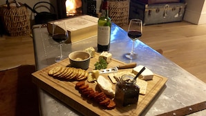 A wooden table with a cheese board, wine glasses, and a bottle of wine. - Characterful Home In Vibrant Village! (Scorton)