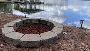 A lakeside property with a dock, a covered pavilion, and a stone fire pit. - Spacious Lakefront Home, Amazing View, Great Dock, Sleeps 18 comfortably-Private (Bracey)