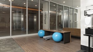 A modern office space with glass walls, a wooden reception desk, and two blue exercise balls. - Fairfield Inn & Suites by Marriott Louisville New Albany IN (New Albany)