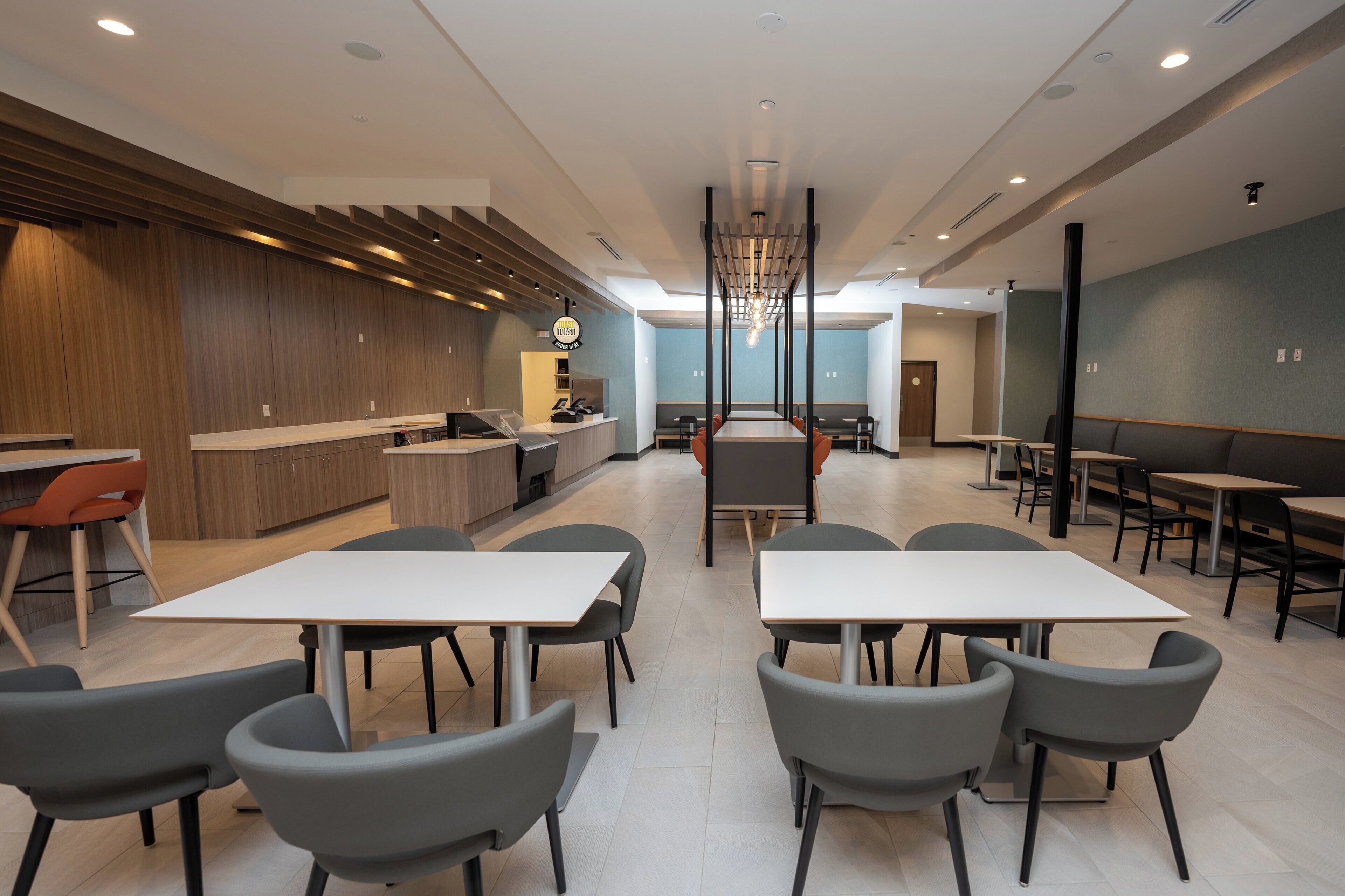 A modern restaurant with a central dining area, a counter, and a bar.