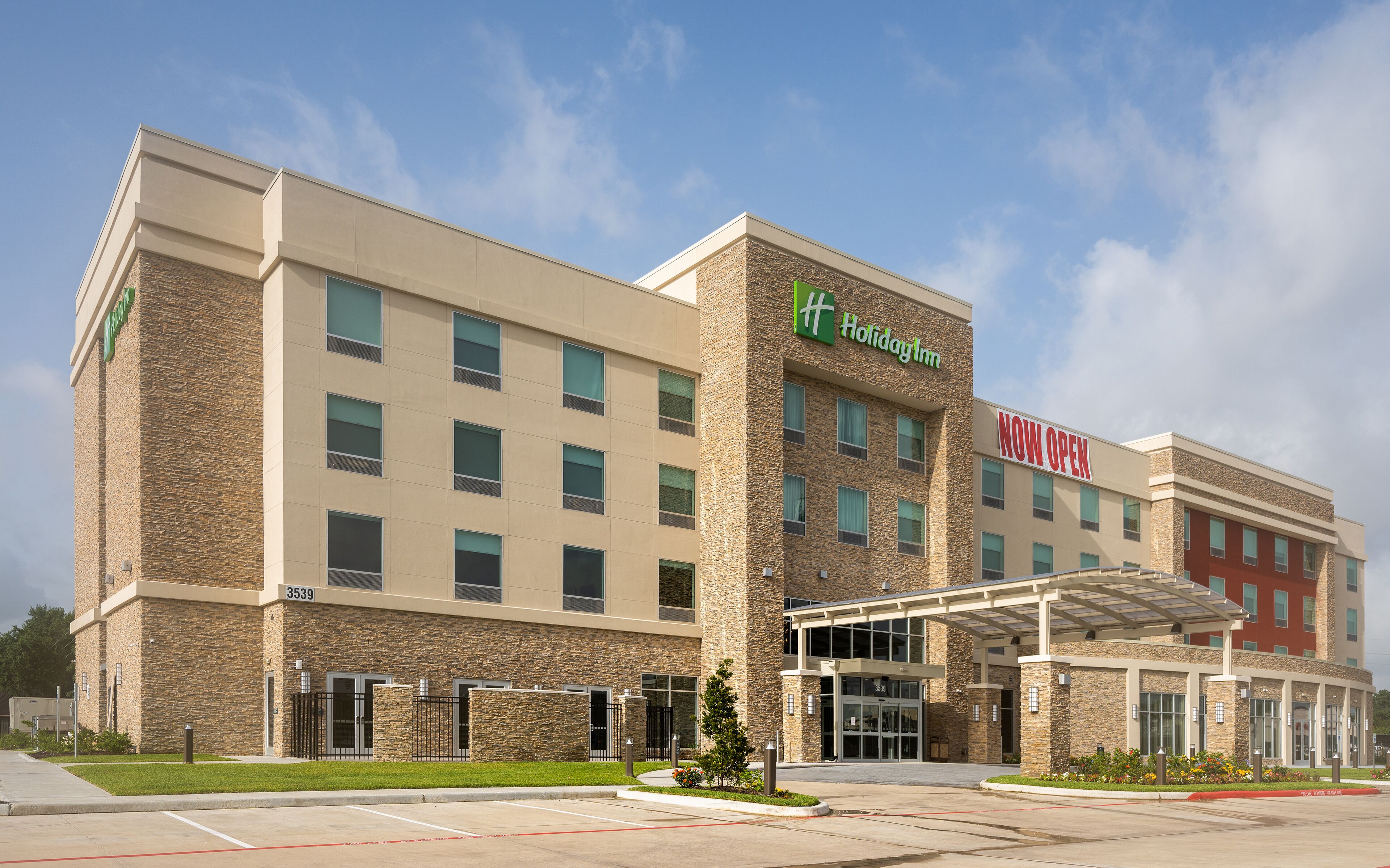 A Holiday Inn Express hotel with a stone facade, multiple windows, and a covered entrance.