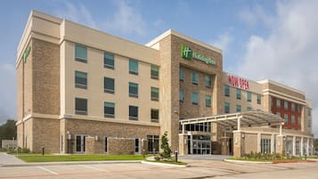 A Holiday Inn Express hotel with a stone facade, multiple windows, and a covered entrance.