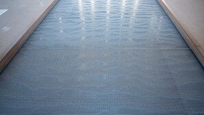A pool with a wooden edge and a textured floor. - Holiday Inn NW Houston Beltway 8 by IHG (Houston)